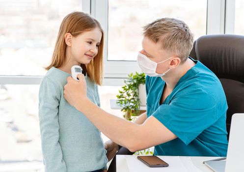 Cute little girl measuring temperature at doctor