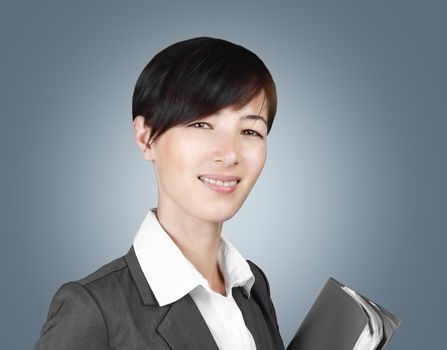 Young smiling woman in a suit with a folder in hands on a gray background