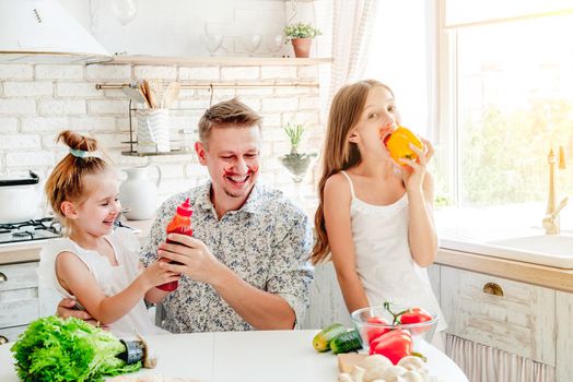 dad with two little daughters preparing pizza in the kitchen