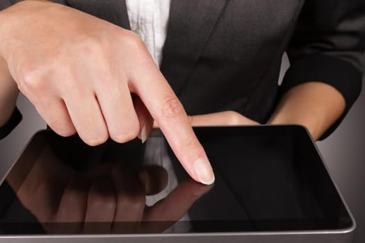 Businesswoman in a suit holding a tablet PC, close-up