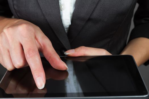 Businesswoman in a suit holding tablet, close-up