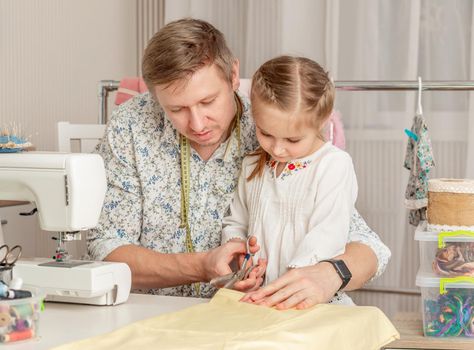 cute little girl and her dad in a sewing workshop