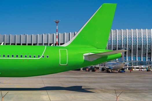 Green passenger airplane at the airport on sunny day photo