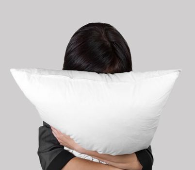 Tired female office worker rests with pillow, concept of stress work