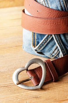 closeup brown leather woman belt with metal heart shaped belt buckle