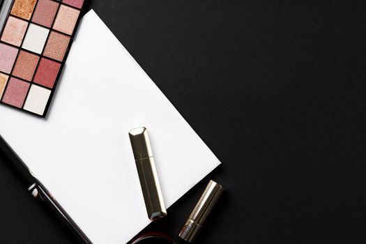 various makeup products on black texture background. close up