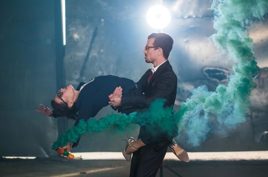 Pasadoble, latin solo dance and contemporary dance - Handsome man and woman dancing into smoke cloud