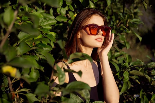 pretty woman wearing sunglasses green leaves glamor posing summer. High quality photo