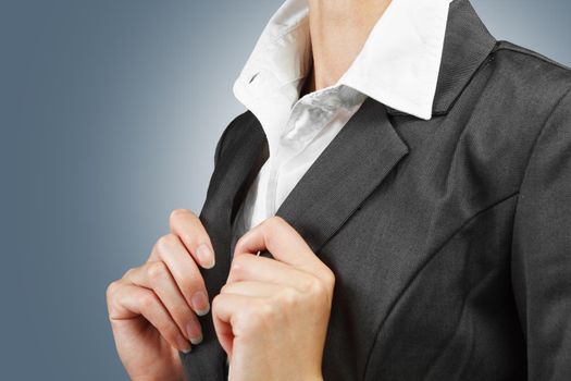 Young businesswoman straightens collar