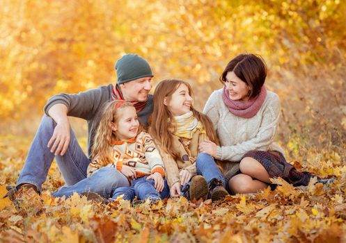 Nice family sitting in autumn park