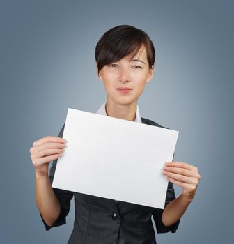 Businesswoman holds a white paper banner, copyspace