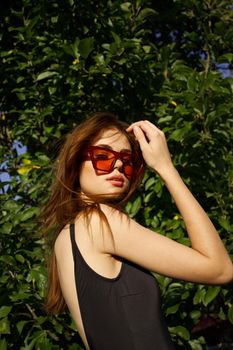 pretty woman wearing sunglasses green leaves summer model. High quality photo