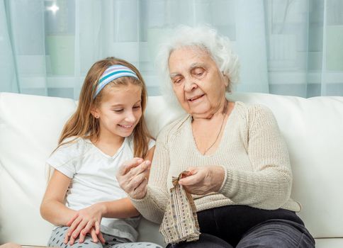 ganddaughter learning to embroider with granny on sofa