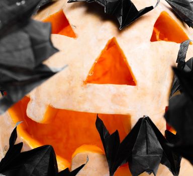 Pumpkin with origami bats made ​​of paper. . Close-up