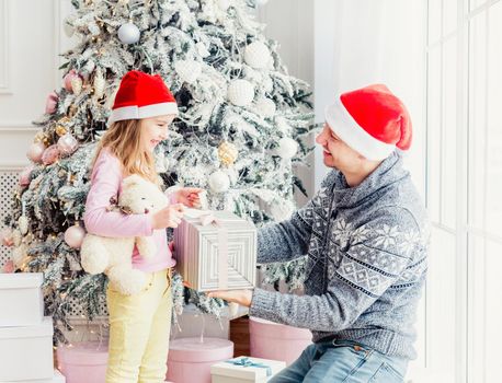 Smiling father giving little daughter christmas gift