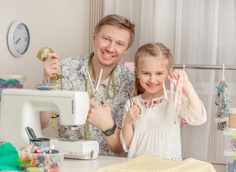 cute little girl and her dad in a sewing workshop