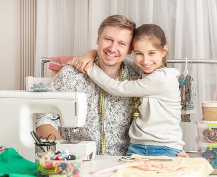 cute little girl and her dad in a sewing workshop