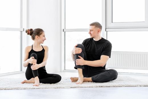 Father with daughter doing fitness exercises in bright room