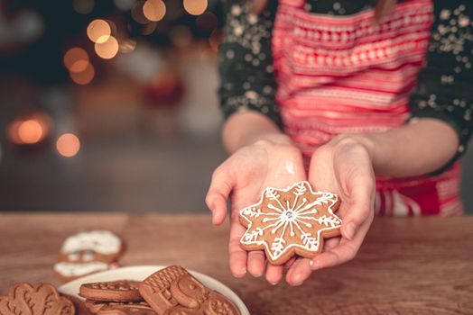 Decorated gingerbread snowflake on girl palm before christmas at home