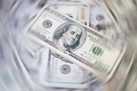 A stack of money. Heap of one hundred dollar bills on money background. Fake money. Shallow depth of field. Selective focus.