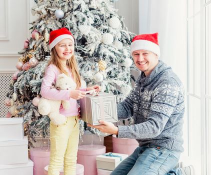 Smiling father giving little daughter christmas gift