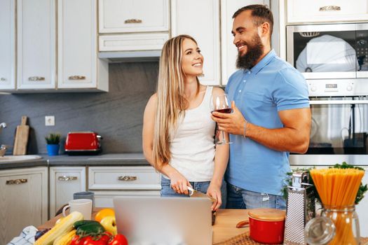 Couple in love preparing meal together in kitchen at home