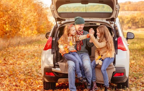 Smiling father with daughters in autumn surroundings