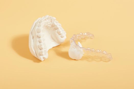 Orthodontic dental theme on  yellow background.Transparent invisible dental aligners or braces aplicable for an orthodontic dental treatment