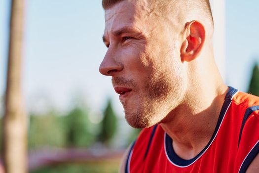 sporty man resting in the park on a bench having a snack. High quality photo