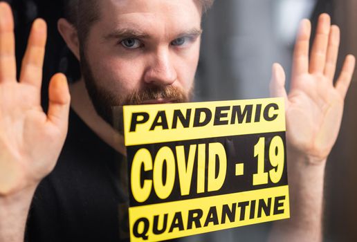 Coronavirus, quarantine and pandemic concept. Sad and sick man of corona virus looking through the window
