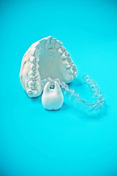 Orthodontic dental theme on blue background. Transparent invisible dental aligners or braces aplicable for an orthodontic dental treatment