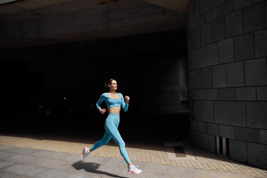 Beautiful fit young woman jogger is running outdoors