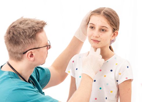 Qualified medic accurately checking sick girls appearance, on white background