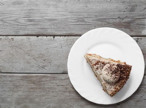 Piece of cake on the wooden table, top view, space for text