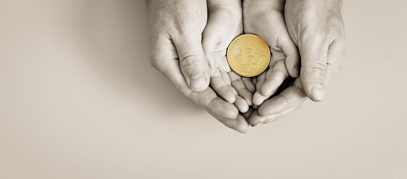 Hands holding bitcoin, world bitcoin day, investing in future children, stability during coronavirus, family investment, corporate social responsibility, investment concept