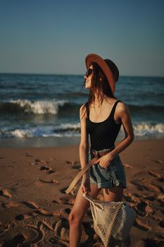 pretty woman in hat walking on the beach ocean travel. High quality photo