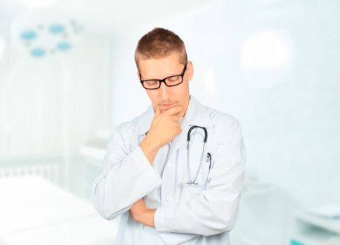 Serious man physician is thinking in a hospital