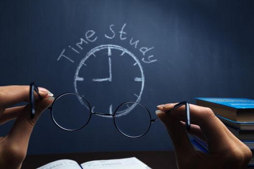 Human hand holding glasses on a blackboard background