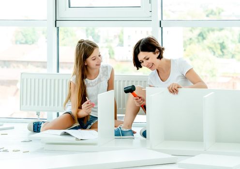 Lovely mother and daughter working together on making new furniture