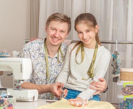 cute little girl and her dad in a sewing workshop