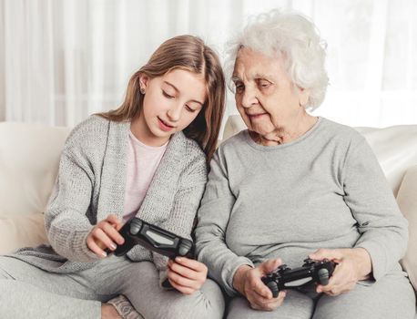 Granddaughter showing grandmother gamepad controls