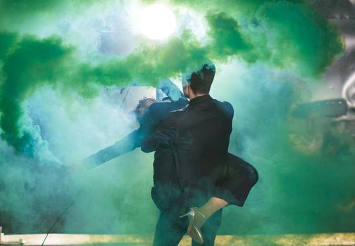 Pasadoble, latin solo dance and contemporary dance - Handsome man and woman dancing into smoke cloud