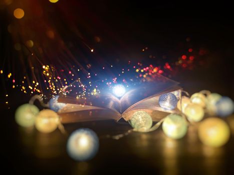 fantasy reading magical image of open antique book over wooden table with glitter overlay .