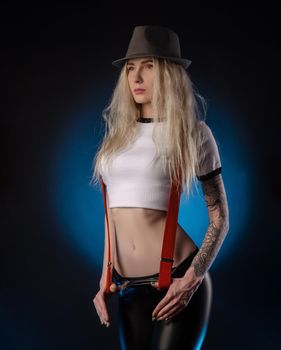 a bright blonde in a hat against a dark background