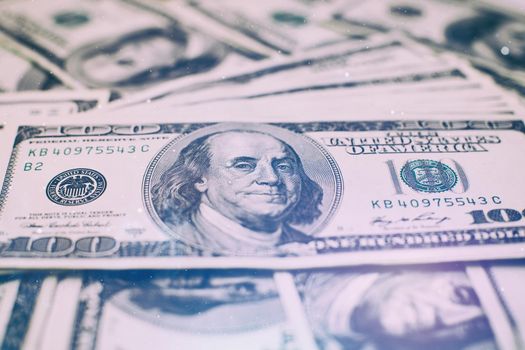 A stack of money. Heap of one hundred dollar bills on money background. Fake money. Shallow depth of field. Selective focus.