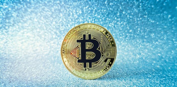 Bitcoin gold coin and defocused glitter background