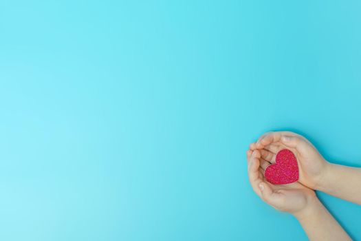 Hands holding a heart glitter, love, family . Taking care of children