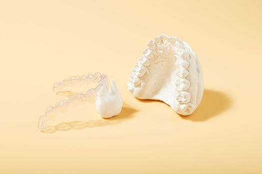 Orthodontic dental theme on  yellow background.Transparent invisible dental aligners or braces aplicable for an orthodontic dental treatment