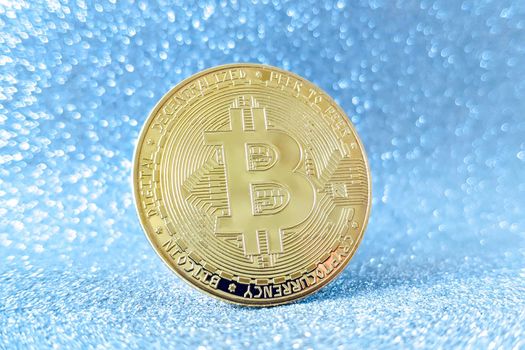 Bitcoin gold coin and defocused glitter background