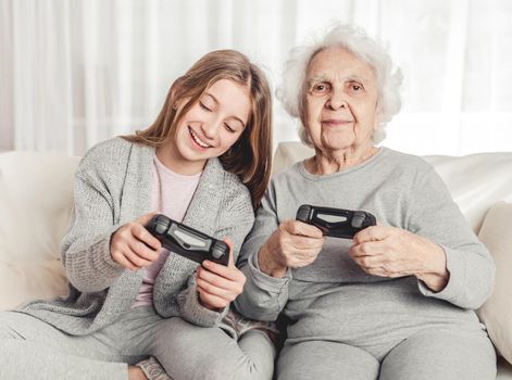 Granddaughter showing grandmother gamepad controls